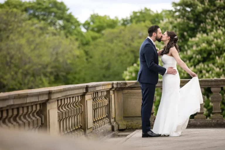 Elegantes Brautpaar auf steinerner Terrasse mit Parkblick – Zeitlose Hochzeitsfotografie NOVA Wien
