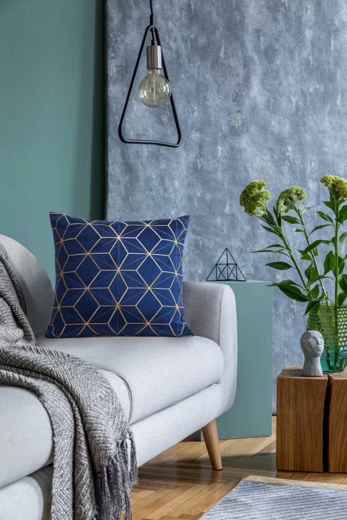Produktfotografie Wien – Zimmer-Atmosphäre mit edlem blauem Sofa-Kissen auf grauem Sofa